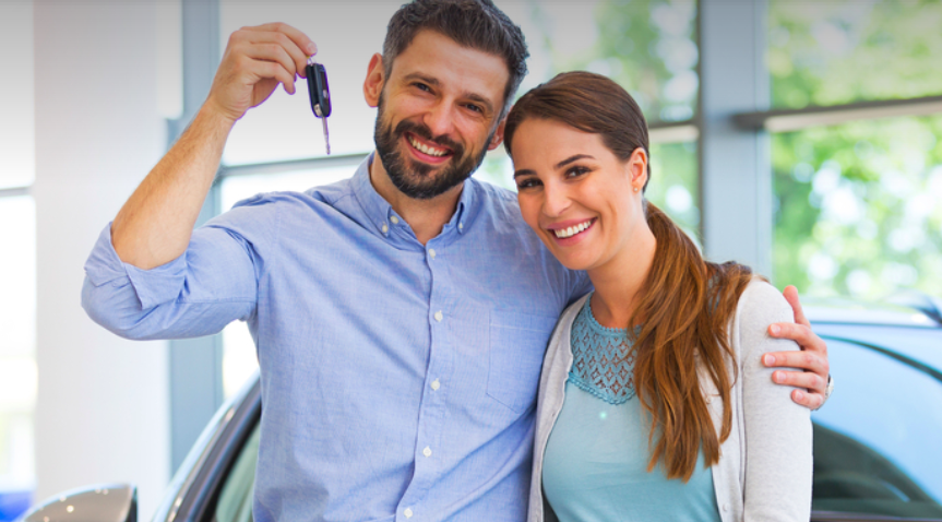 A happy couple who just purchased a car