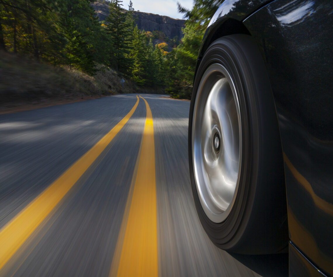 Black sports car motion country road.